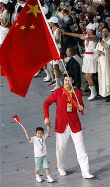Yao Ming, China's flagbearer, walked with a 9-year-old survivor of the Sichuan earthquake, Lin Hao.